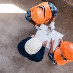 top view of constructors and businessman standing and pointing w